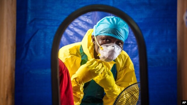 FILE -A healthcare worker dons protective gear before entering an Ebola treatment center in the west of Freetown, Sierra Leone, Oct. 16, 2014..