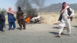 Pakistani local residents gather around a burning vehicle hit by a U.S. drone strike, May 21, 2016. Afghan Taliban Mullah Akhtar Mansoor was the target of the drone near Dalbandin, Baluchistan, Pakistan.