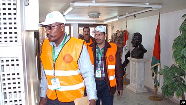 A handout picture released by the Syrian Arab News Agency (SANA) shows Arab League observers walking in a government building during their visit to Daraa in southern Syria, December 29, 2011.