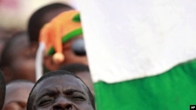 A supporter of Ivory Coast's incumbent leader Laurent Gbagbo sings the national anthem during a rally in Abidjan, 29 Dec 2010