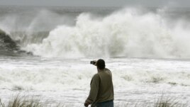  Yon nèg ap pran foto gwo lanm-lanmè siklòn Sandy kòmanse pwovoke nan vil Ocean City, nan Eta New Jersey.