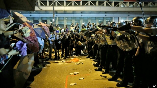 Cảnh sát chống bạo động chĩa súng ngăn người biểu tình tiến vào khu thương mại Mong Kok, ngày 19/10/2014.
