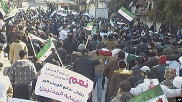 Demonstrators protest against Syria's President Bashar al-Assad after Friday prayers, with banners that read, 'Yes to support the Free Army,' in Al Qusour, Homs, Syria, March 2, 2012.
