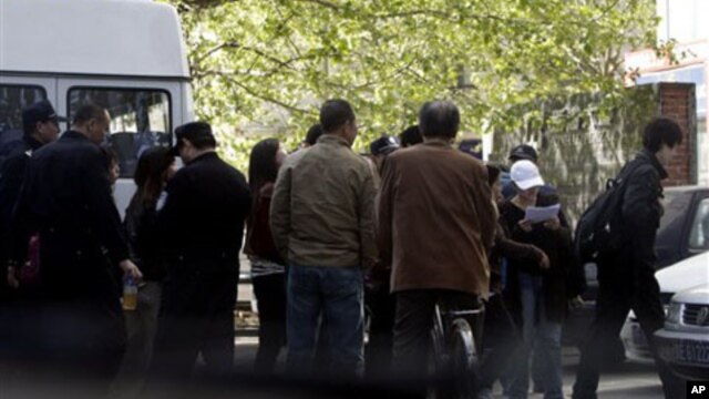 Chinese youths detained by police officers from an area where members of a unregistered church planned to hold Easter service are led into a police station in Beijing Sunday, April 24, 2011.
