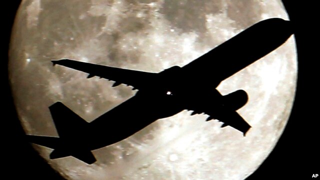 Un avión parece cruzar la luna al aproximarse al aeropuerto internacional de Los Angeles, en California.