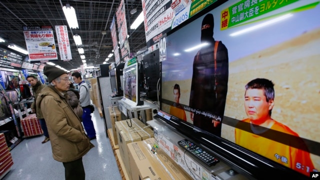 A man watches a television broadcasting a news about detained two Japanese, at an electronics store in Tokyo, Jan. 20, 2015. 
