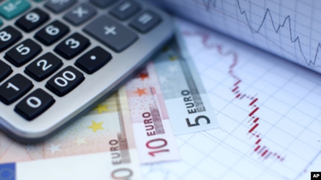 Euro banknotes and a calculator are placed on a currency graph and ticker (File)