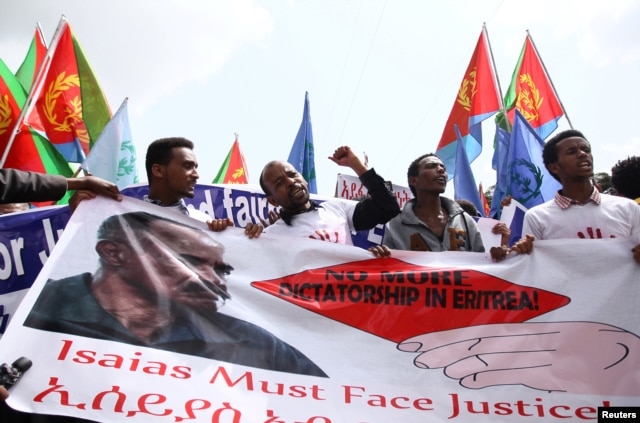 Eritrean refugees chant slogans as they hold a banner with the picture of President Isaias Afwerki during a demonstration in support of a U.N. human rights report accusing Eritrean leaders of crimes against humanity, in Ethiopia's capital, Addis Ababa, Ju