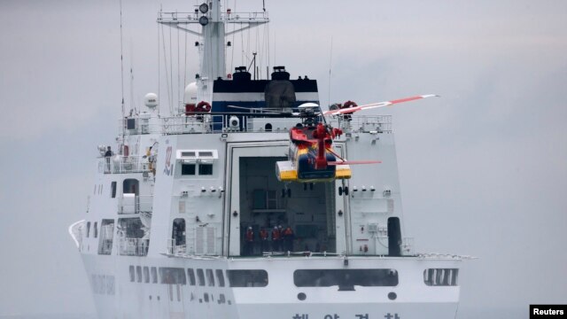 Sebuah helikopter menuju kapal penjaga pantai  dalam operasi pencarian dan penyelamatan korban tenggelamnya Feri Sewol di Jindo, 18/4/ 2014. 