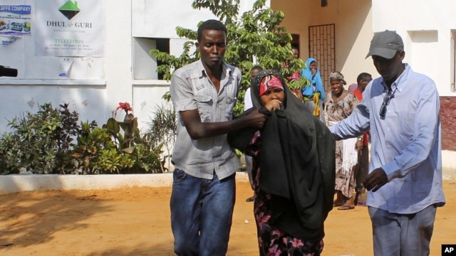 People assist a girl wounded in a suicide blast at popular restaurant in Mogadishu, November 3, 2012.