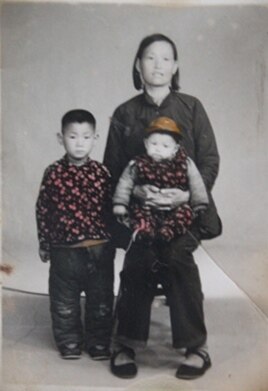 坐在妈妈膝盖上只有几个月大的小光诚，那时还是个视力健全的孩子。