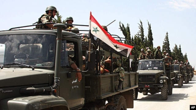 In this photo taken during a government-organized visit for media, Syrian army soldiers ride on their military trucks as they enter the villages near the town of Jisr al-Shughour, north of Damascus, June 10, 2011