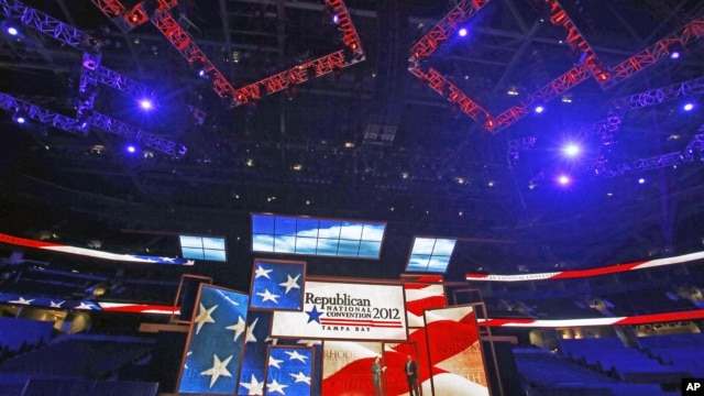 Republican National Committee Chairman Reince Priebus (L) and convention CEO William Harris unveil the stage and podium for the 2012 Republican National Convention, August 20, 2012, at the Tampa Bay Times Forum in Tampa, Florida.