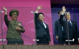 N. Korea’s National Defense Commission Vice Chairman Hwang Pyong So, left, and N. Korea’s Workers Party secretaries, Choe Ryong Hae and Kim Yang Gon wave as their team marches into the stadium at Asian Games in Incheon, S. Korea, Oct. 4, 2014.