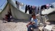 A Syrian refugee boy sits outside his family's tent at a temporary camp in the Lebanese town of Marj near the border with Syria, May 20, 2013. 