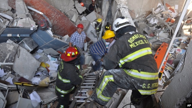 Regu pemadam kebakaran dari sektor Tacubaya dan para pekerja lainnya melakukan pencarian korban dengan menggali bangunan yang runtuh akibat ledakan di kantor pusat perusahaan minyak negara Meksiko, PEMEX, 31 Januari 2013. (AP Photo/Guillermo Gutierrez).