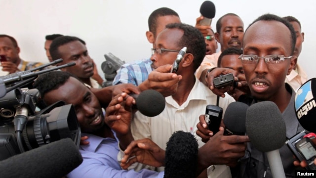 FILE - Somali journalist Abdiaziz Abdinur (R) talks to reporters after the high court freed him in the capital of Mogadishu, March 17, 2013.