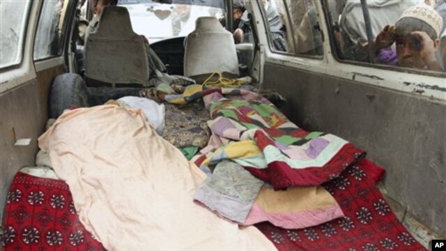 An Afghan boy peeks into a bus carrying the body of a person who was allegedly killed by a U.S. service member in Panjwai, Kandahar province south of Kabul, Afghanistan, March 11, 2012