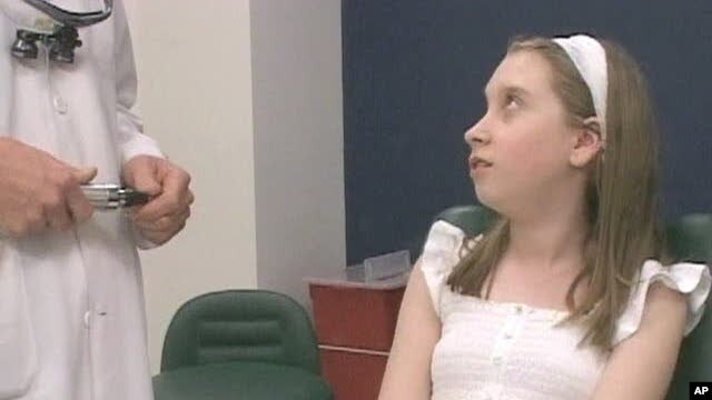 Romanian Andrea Nemethi, 12, speaks with Doctor Aaron Fay, a surgeon at Massachusetts Eye and Ear Infirmary