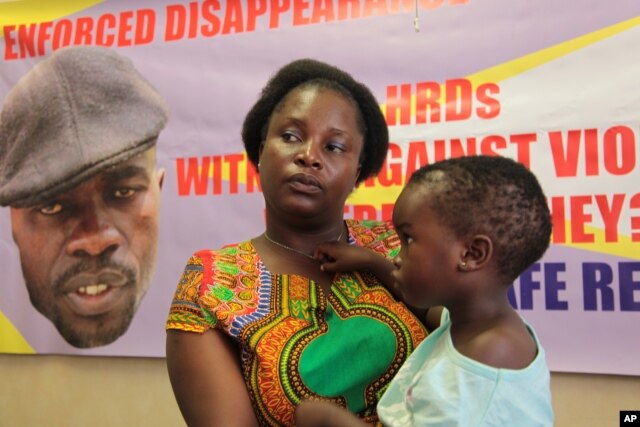 FILE - Sheffra Dzamara, wife of activist Itai Dzamara, holds her daughter and speaks to The Associated Press in Harare, March 8, 2016. Dzamara was pleading for the return of her activist husband, abducted by suspected state security agents.