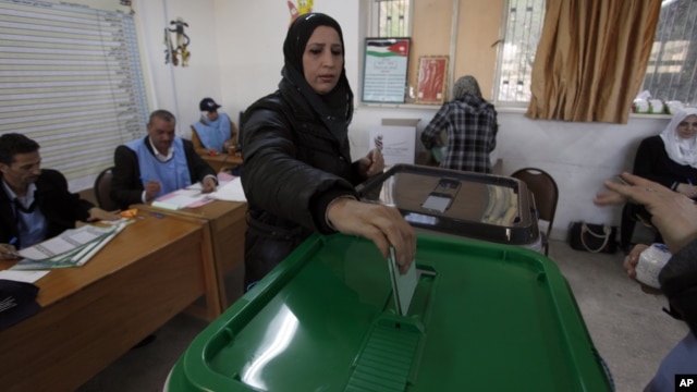 A woman casts her vote at  a polling station during the first hours of the Jordanian Parliamentary elections, in Al-Salt, Jordan, January 23, 2013.