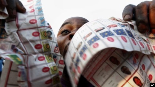 Supporters of opposition candidate Etienne Tshisekedi show what they claim are badly printed fraudulent photocopies of election ballots they say they found in the Bandal commune in Kinshasa, DRC, November 28, 2011.