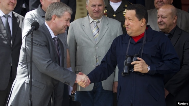 Venezuela's President Hugo Chavez (R) and First Deputy Prime Minister of Belarus Vladimir Semashko shake hands after their meeting at Miraflores Palace in Caracas, Venezuela, June 2, 2012.