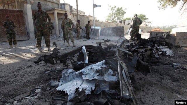 Somali government soldiers secure the scene of a suicide attack next to the gate of the Presidential Palace in Mogadishu on February 21, 2014.