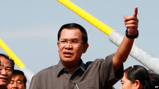 Cambodia's Prime Minister Hun Sen, center, gestures during a ceremony inaugurating the country's longest bridge in Neak Loeung, southeast of Phnom Penh, Cambodia, Wednesday, Jan. 14, 2015. Hun Sen, Cambodia's tough and wily prime minister, marks 30 years