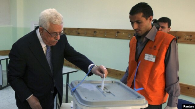 Palestinian President Mahmoud Abbas casts his vote for municipal elections at a polling station in Al-Bireh, next to the West Bank city of Ramallah, October 20, 2012.  