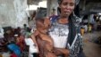 An internally displaced woman holds her malnourished son at a new settlement in Somalia