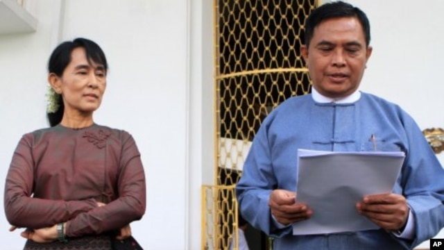 Burma's Labor and Social Welfare Minister Aung Kyi, right, reads a statement to the media after meeting with Aung San Suu Kyi, left, at Seinlekhanthar government guest house in Yangon, July 25, 2011