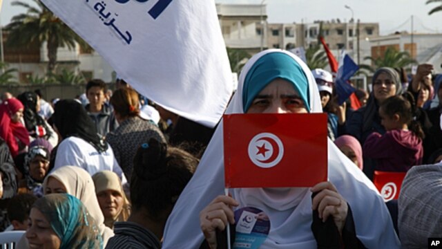 A supporter of the Islamic Ennahda party displays her national flag during a rally in Ben Arous, south of Tunis, October 21, 2011.