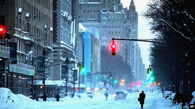 Pedestrians walk along Central Park West in New York Monday after a blizzard hammered the city and much of the Northeast, 27 Dec 2010
