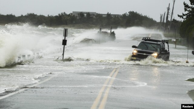 A truck drives through water pushed over a road by Hurricane Sandy in Southampton, New York, October 29, 2012.