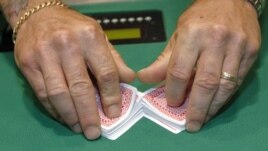 A man shuffles cards before he deals a poker game