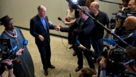 Friends of the Earth campaign leader Geert Ritsema, second left, and plaintiff Eric Dooh, left, give a statement after the ruling in the court case of Nigerian farmers against Shell, in The Hague, Netherlands, January 30, 2013. 