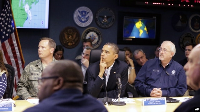 President Barack Obama, center, attends a briefing with Federal Emergency Management Agency administrator Craig Fugate, right, at the National Response Coordination Center at FEMA Headquarters in Washington, on Sunday, Oct. 28, 2012.