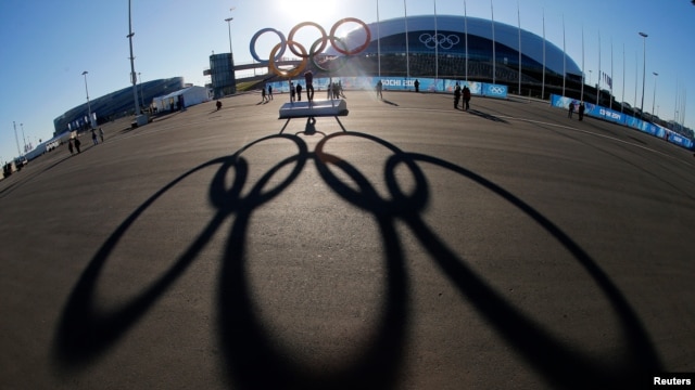 File - The Olympic rings are cast in shadow as the sun sets behind the Bolshoy Ice Palace as preparations continue at the Olympic Park for the 2014 Winter Olympics in Sochi, Russia, Feb. 3, 2014.