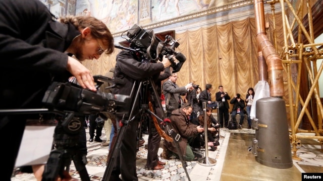 Media films the stove at the Sistine Chapel in the Vatican, March 9, 2013.