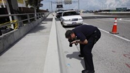Un investigador fotografía una tarjeta de crédito del caníbal de Miami, Rudy Eugene, encontrada en la escena del crimen, en Miami.