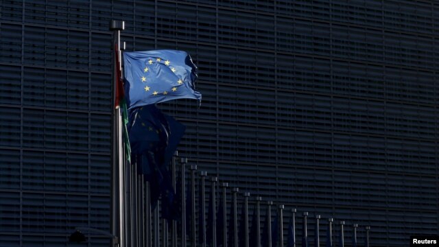 FILE - A European Union flag flutters outside EU Commission headquarters in Brussels, Belgium, Jan. 12, 2016.