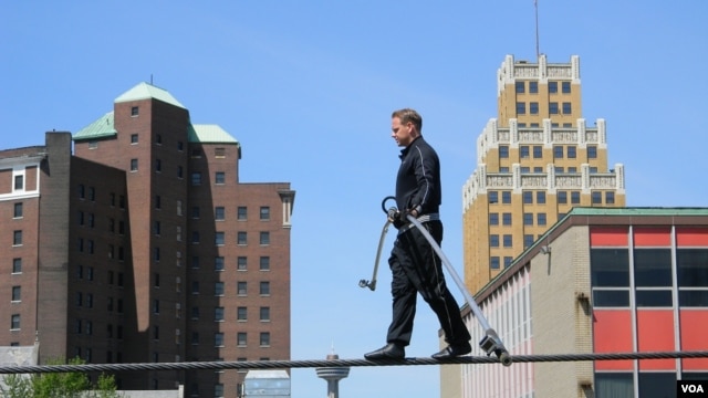 Nik Wallenda, on a wire three meters above a mostly empty parking lot, practices for his walk across Niagara Falls. (D. Robison/VOA)