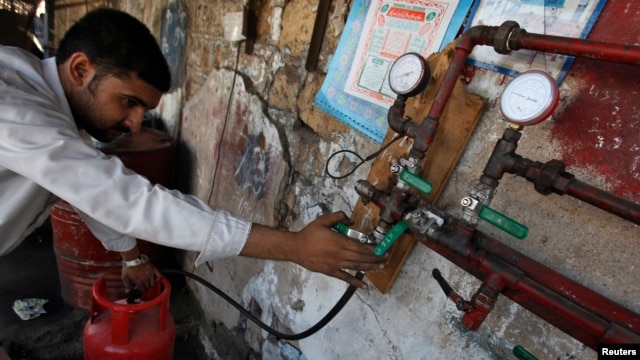 A man gauges liquefied petroleum gas in a cylinder at his makeshift shop in Karachi on April 22, 2010. Pakistan is battling a chronic energy shortage, stifling industry and angering the public. 