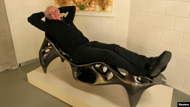 Wilfried Vancraen, chief executive of Materialise, poses for Reuters on a 3D KOL/MAC Root Chair by Sulan Kolatan and William MacDonald, built in one piece on Materialise's Mammoth Stereolithography Machine, in Leuven, January 24, 2013.