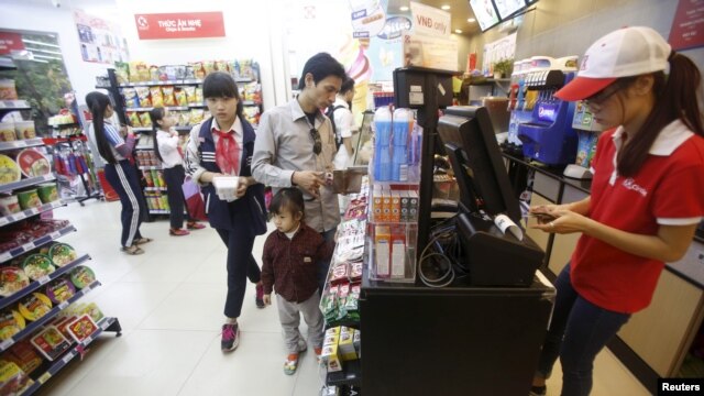 Nhân viên kiểm tra hóa đơn của khách hàng bên trong siêu thị ở Hà Nội, ngày 12/10/2015.