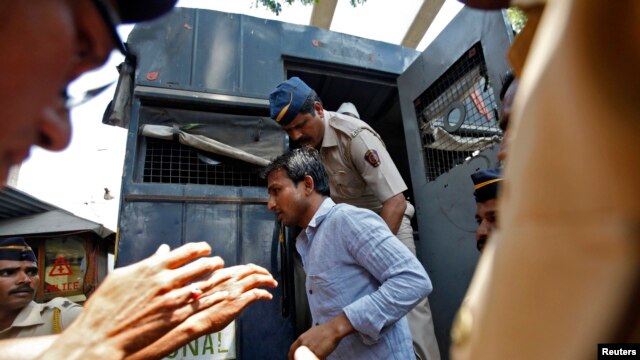 Cảnh sát áp tải một trong bốn người đàn ông bị kết tội cưỡng hiếp phóng viên ảnh bên ngoài nhà tù ở Mumbai, ngày 20/3/2014.