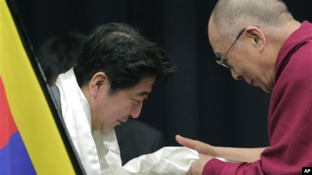 Tibetan spiritual leader the Dalai Lama, right, gives a white Tibetan scarf  to Japan's main opposition Liberal Democratic Party President Shinzo Abe during a seminar held by Japanese Diet members in Tokyo, Tuesday, Nov. 13, 2012.  (AP Photo/Itsuo Inouye)