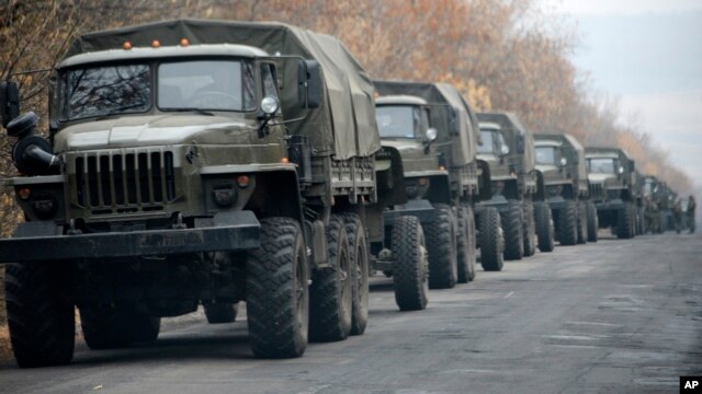 Unmarked military vehicles are parked on a road outside the separatist rebel-held eastern Ukrainian town of Snizhne, 80 kilometers from Donetsk, Nov. 8, 2014.  