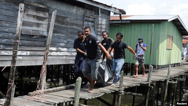 Villagers carry the body of a dead gunmen that was killed on Saturday, Simunul village in Sabah's Semporna district, March 4, 2013. 